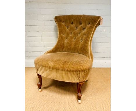 A Victorian upholstered bedroom chair with button back standing on walnut cabriole legs 
