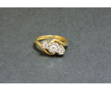 An 18ct gold three stone diamond crossover ring, with illusion setting