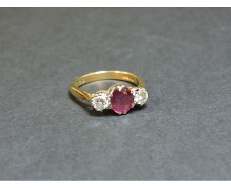 An 18ct gold ruby and diamond three stone ring