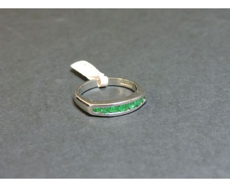 An 18ct white gold emerald half eternity ring