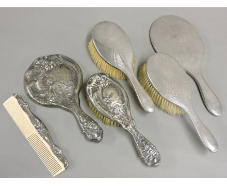 An American Art Nouveau silver vanity set, including brush, comb and mirror, together with a George V silver vanity set with 