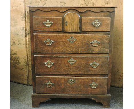 An East Anglian oak chest, of five drawers centred with an arched cupboard, on bracket feet, 82cm wide