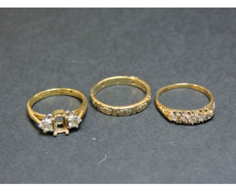 An 18ct gold three stone diamond ring, one stone deficient, a five stone diamond ring, and a 9ct gold diamond band ring