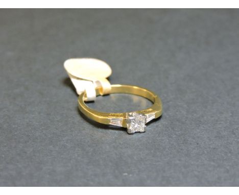 An 18ct gold single stone princess cut diamond ring, with tapered baguette cut shoulders