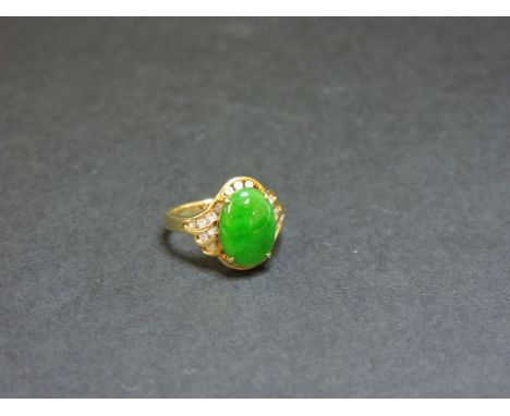A single stone jade ring, with channel set diamond shoulders marked 585