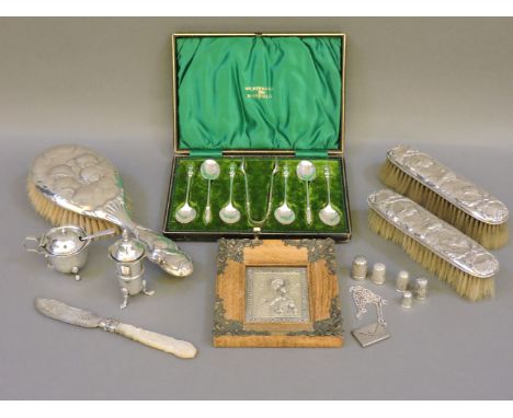 Three silver backed brushes, embossed with Reynolds Angels, a silver pepper pot, a mustard pot, a 19th century butter knife, 