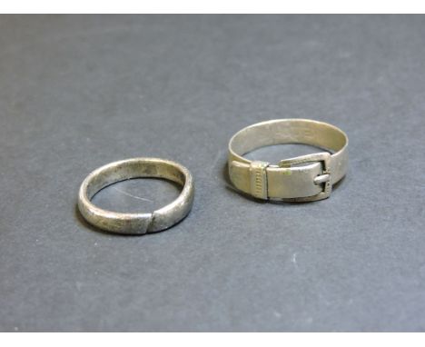 A white metal buckle ring, with Cyrillic script inside, and a white metal band ring, possibly early posy style, cut through