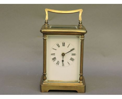 A small brass carriage clock, with white enamel face and Roman numerals