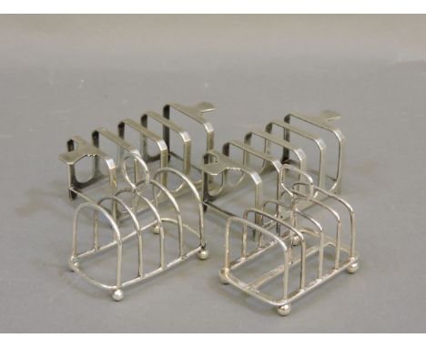 A pair of silver toast racks, Mappin & Webb, Sheffield 1937, and two further small toast racks, Birmingham 1927 and Sheffield