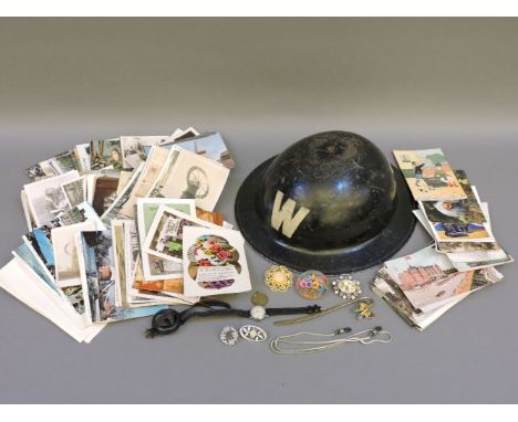 A WWII air raid warden's tin helmet, various postcards, and costume jewellery