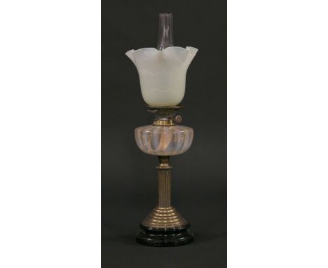 A Victorian brass oil lamp,with round black ceramic base, stepped foot and reeded column, with vaseline ripple reservoir, Hin