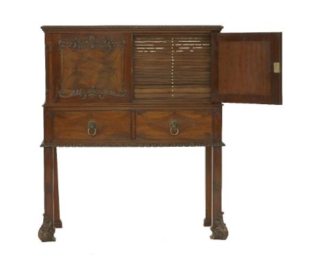 A mahogany collector's cabinet,in the Chippendale style, the two doors with carved detail moulding, enclosing two sets of eig