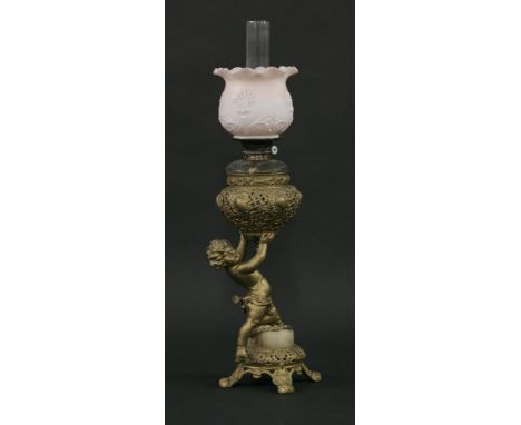 A Victorian spelter cherub oil lamp,the base with four feet, marble plinth and semi-kneeling figure holding up a pierced bowl