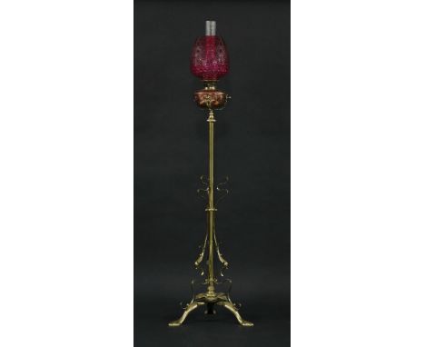 A late Victorian floor-standing brass column oil lamp,with triform leaf base and telescopic column, the lamp with copper rese