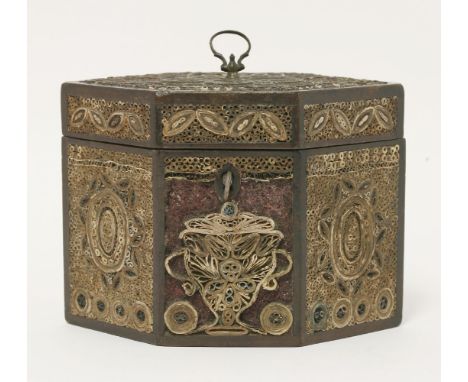 A George III rolled paper filigree hexagonal tea caddy, the front panel with rolled paper urn, now on a crushed red glass bac