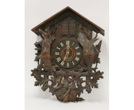 A 'Black Forest' cuckoo wall clockwith carved dead hare and woodcock, oak leaves, gun and powder flask, two doors with a bird