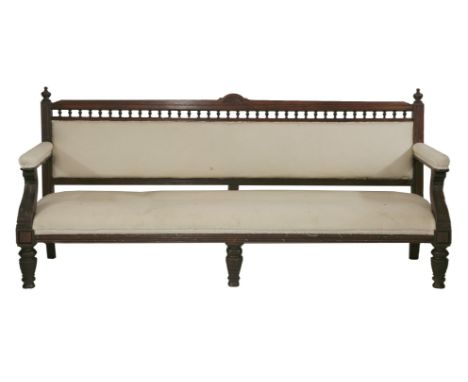 A Victorian oak long hall bench,with a carved frame with an open spindle gallery, carved leaf arms and turned legs,208cm 