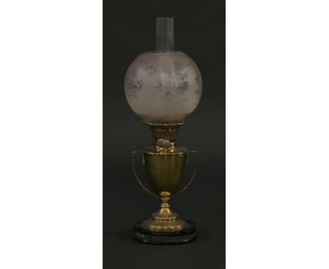 A Victorian brass oil lamp,the two-handled trophy cup on round black ceramic plinth, with etched foliate globe shade,53cm hig