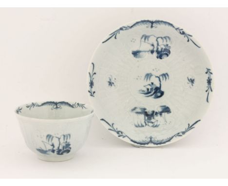 A rare Worcester blue and white Tea Bowl and Saucer,c.1755-1770, embossed with strap flutes and cartouches, painted with pane