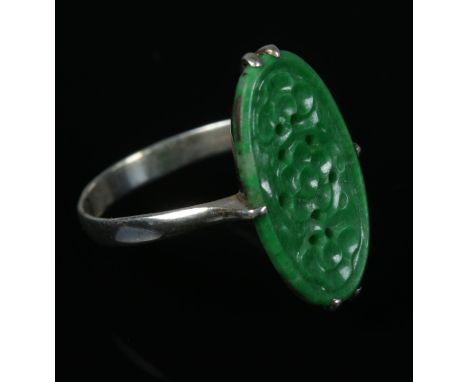 A white metal ring set with jade coloured tablet.  