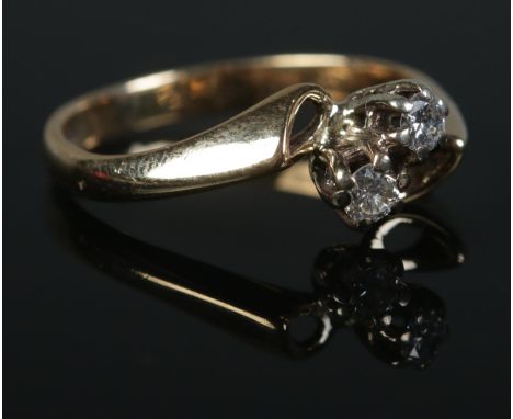 A 9ct Gold and two stone diamond crossover ring. Size LÂ½. Total weight: 2.2g.  