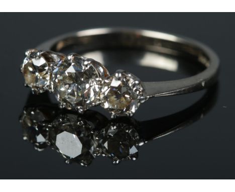 An 18ct white gold three stone diamond ring. Size K. 2.64g.  