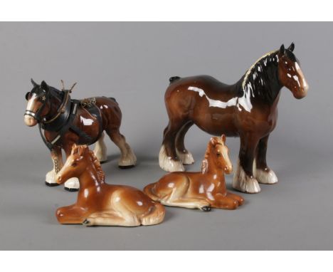 A collection of ceramic horses including Beswick shire horse, one shire horse in tack and two resting foals.  