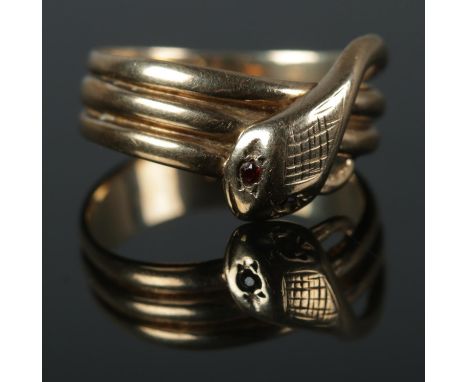 A 9ct coiled snake ring featuring garnet set eyes and cross hatch detail to head. Size R 4.67g.  Stones in eyes good. Some we