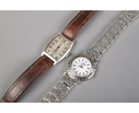 A vintage manual silver watch with leather strap, together with a ladies EON quartz wristwatch with silver strap.  Manual wat