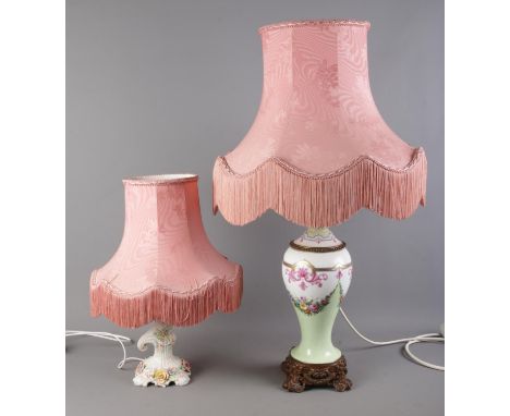 Two ceramic table lamps, one with floral detailing, the other with a decorative metal base. Complete with pink frilled shades