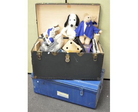 A large travelling trunk containing various items including ice skates, dressing table mirror, soft toys, iron, cooking items