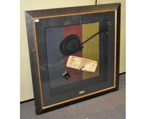 A large diorama behind glass, comprising bowlers hat, walking stick, Financial Times, pipe and cigarette case, plaque to bott