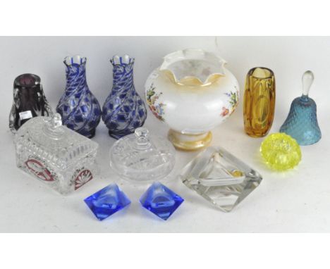 A collection of assorted glassware, mostly coloured, including a hand bell, vases, an ashtray and more