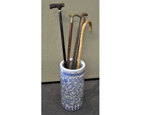 A ceramic blue and white umbrella/stick stand; together with five assorted walking sticks, 46cm high x 22cm diameter