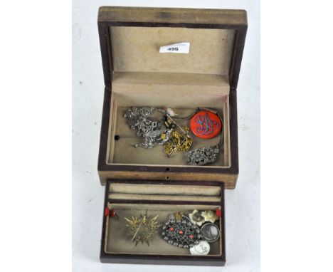 A vintage jewellery box containing a selection of costume jewellery, including brooches