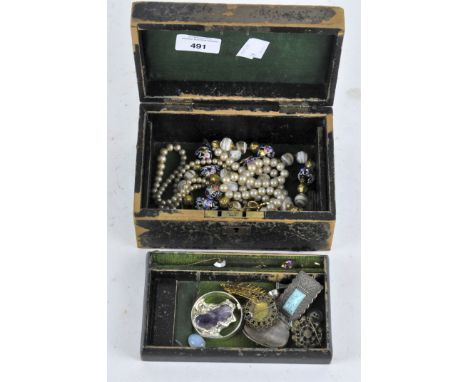 A vintage jewellery box containing costume jewellery, including brooches and pins