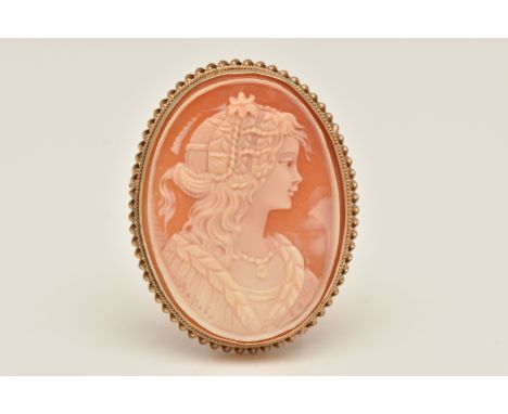 A 9CT GOLD CAMEO BROOCH, of an oval form, with a carved shell cameo depicting a lady in profile, collet set within a fine rop