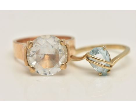 TWO GEM SET RINGS, the first a large circular cut colourless sapphire, prong set in yellow metal, wide tapered shank, stamped