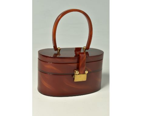 WILARDY: A 1950'S  OVAL FORM BROWN TORTOISE LUCITE, a two tiered interior design, curved clasp and handle, lid interior is mi