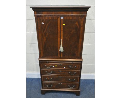 A REPRODUCTION MAHOGANY CABINET, fitted with double cupboard doors, over a brushing slide and four drawers, raised on bracket
