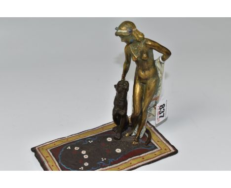 A BERGMAN-STYLE BRONZE FIGURE, of a nude female and a big cat standing on a carpet, with painted details and gilding to the f