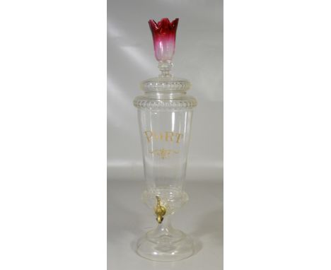 Clear crystal Port liquor dispenser, brass spigot needing a cork, the lid with a tulip finial shaded to cranberry, marked JA 