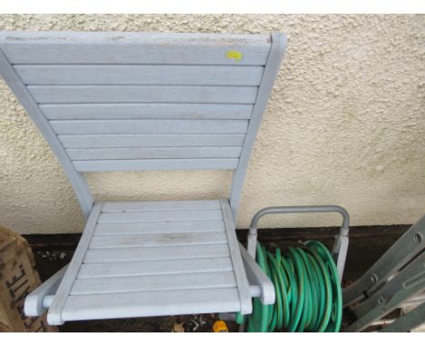 A WOODEN FOLDING PATIO CHAIR PAINTED IN LIGHT GREY AND HOSE ON REEL