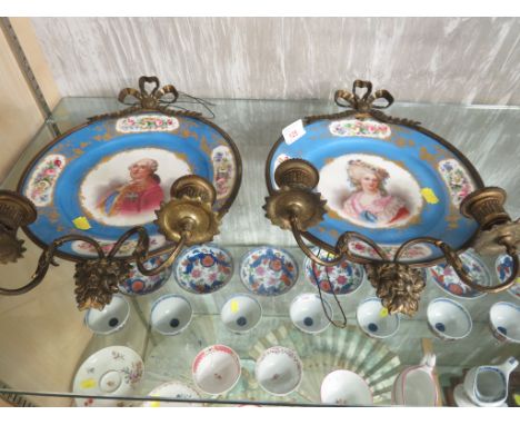 A PAIR OF SEVRES PORCELAIN HAND-PAINTED PLATES DEPICTING A PORTRAIT OF A MAN AND WOMAN WITH FLORAL BORDERS AND GILT METAL MOU