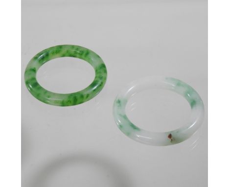 A jade coloured hardstone bangle, together with another, 8cm diameter
