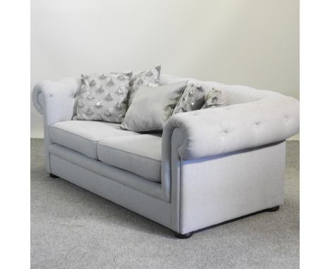 A modern grey upholstered chesterfield sofa, 180cm, with a collection of cushions