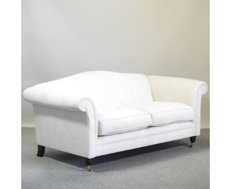 A cream upholstered hump back sofa, on turned legs and castors, 190cm