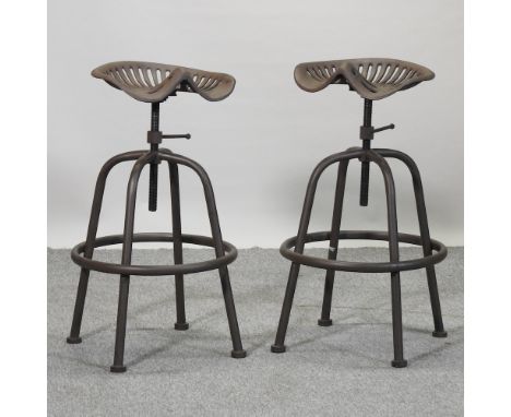 A vintage style metal adjustable tractor seat stool, together with another similar