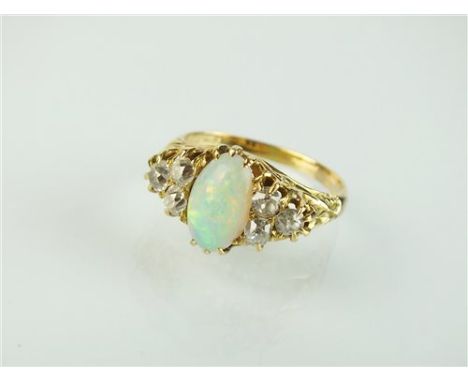 A seven stone opal and diamond ring, designed as a central oval cabochon opal flanked to each side by three old cut diamonds,