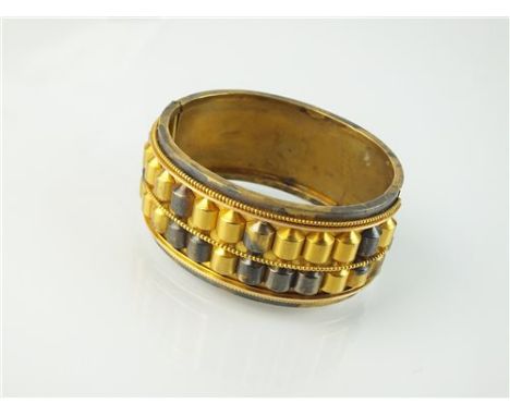 A Victorian yellow metal hinged bangle, with bead and dome decoration, the box link clasp stamped 'D &amp; F'